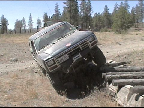 1985 Ford Bronco - This SUV is attempting to cross a series of logs in an outdoor setting.
