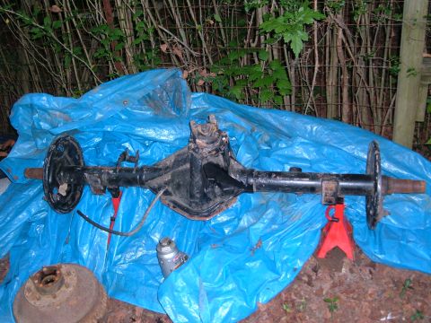 1991 Ford Bronco - A rear axle assembly is shown, supported by jack stands and covered with a blue tarp.