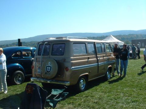 1978 Ford Mustang II - A vintage Ford van is displayed outdoors with other vehicles and attendees.