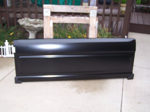 1986 Ford Bronco - A black tailgate is shown outdoors, resting on a concrete surface.