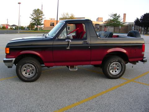 1990 Ford Bronco - This 1987 Ford Bronco features a two-tone paint job and a removable top, viewed from its side profile.