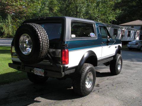 1994 Ford Bronco - Rear view of a 1994 Ford Bronco with a spare tire on the back and two-tone paint.
