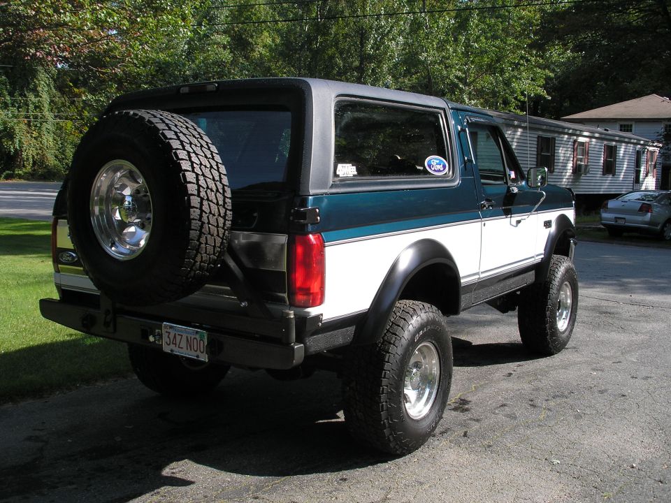 1994 Ford Bronco, rear view, with spare tire mounted on back. Teal and white paint