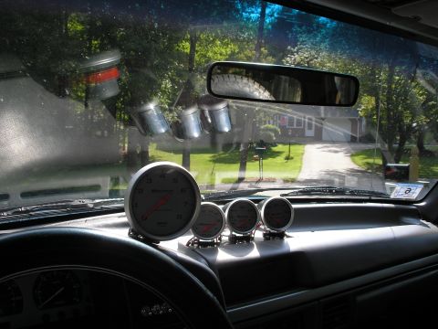 1994 Ford Bronco - Multiple aftermarket gauges are mounted on the dashboard, visible through the windshield.