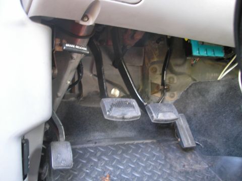 1994 Ford Bronco - The interior footwell of a vehicle is shown, the brake, clutch, and gas pedals.