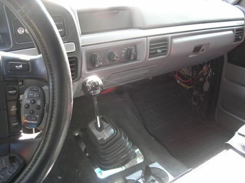 1994 Ford Bronco - Interior view of a vehicle's dashboard and manual transmission, with exposed wiring visible.