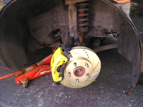 1994 Pontiac Trans Am - Close-up of a yellow brake caliper and drilled rotor, with 'Trans Am' text visible on the caliper.