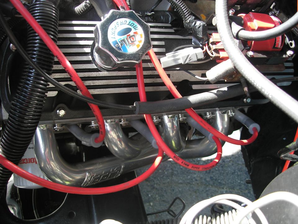 Engine bay with chrome headers and red spark plug wires