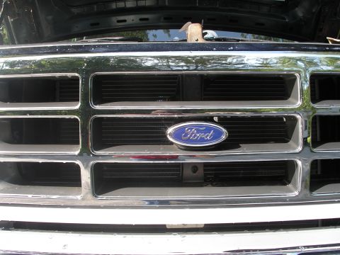 1994 Ford Bronco - Close-up of the front grille on a 1994 Ford Bronco, the iconic Ford oval emblem.