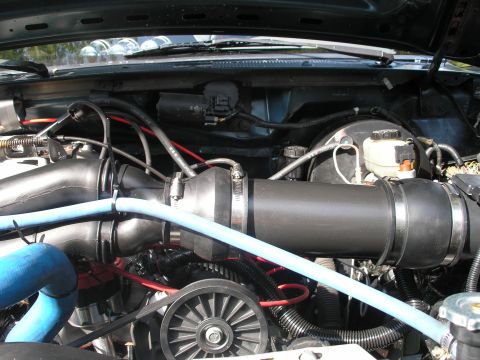 1994 Ford Bronco - Close-up of an engine bay, focusing on the intake system and associated components.