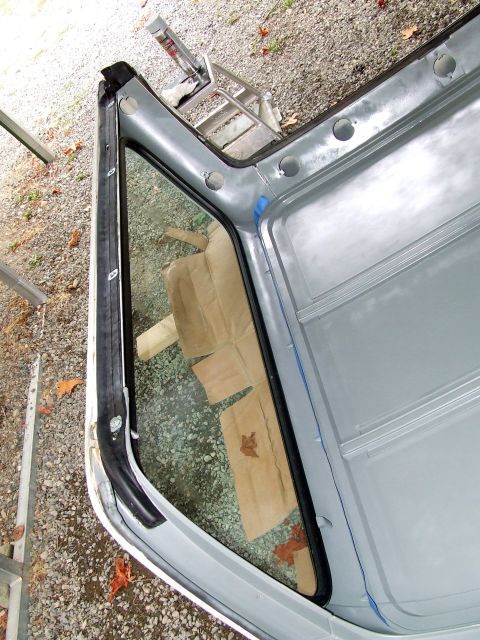 1979 Ford Bronco - Close-up view of the interior of a vehicle's roof and window frame, with cardboard protecting the interior.
