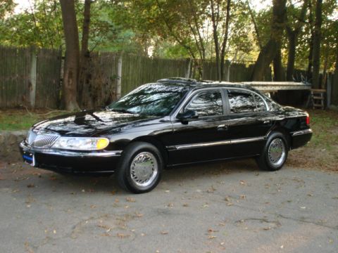 1997 Ford Crown Victoria - A black Lincoln Continental is shown from the front three-quarter view, parked outdoors.