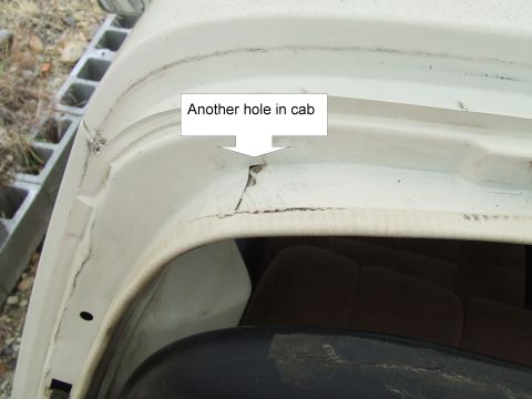 1979 Ford Bronco - A close-up view of damage and rust on the upper corner of a vehicle's cab.