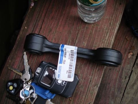 1997 Ford Crown Victoria - A Ford suspension part with its original label is shown next to a set of keys and a bottle of water.