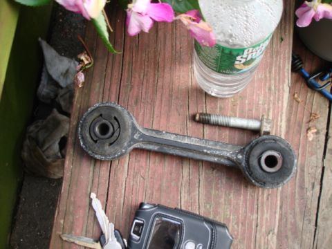 1997 Ford Crown Victoria - A car suspension part, keys, and a cell phone are laid out on a wooden surface.
