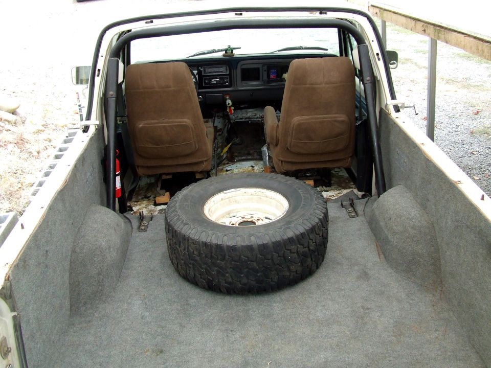 Ford Bronco rear cargo area with rear seat removed and spare tire lying on the floor