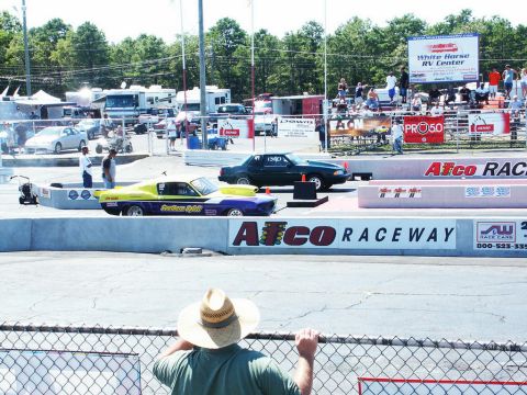 2001 Mercury Grand Marquis - Two cars prepare for a drag race at Atco Raceway, with spectators and RVs visible in the background.