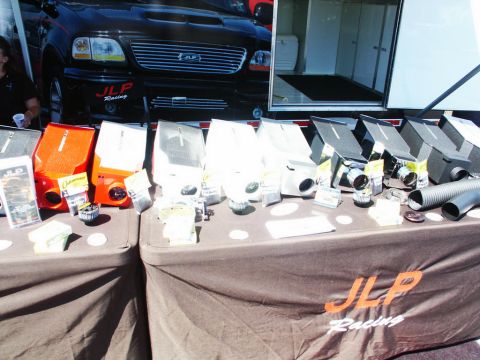 2001 Mercury Grand Marquis - A black Ford F-150 truck is parked behind a table displaying various automotive parts.