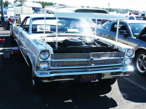 2001 Mercury Grand Marquis - A vintage American sedan is displayed with its hood open at an outdoor car show.