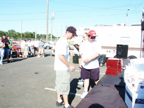 2001 Mercury Grand Marquis - A car show event with people gathered around an awards table, with a trailer and other vehicles visible in the background.