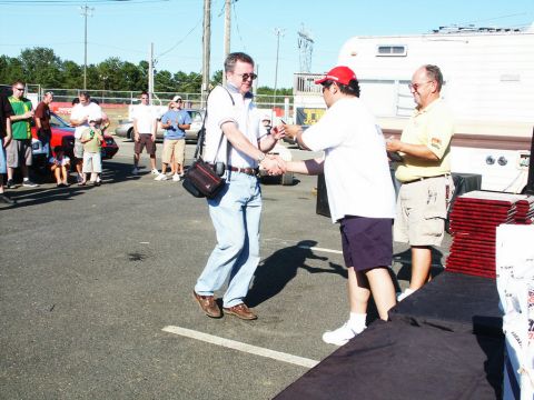 2001 Mercury Grand Marquis - People interact at an outdoor car show event with vehicles and a trailer visible.