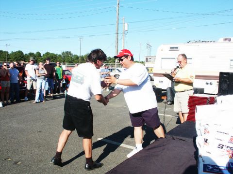 2001 Mercury Grand Marquis - An award is being presented at an outdoor car show event with spectators and vehicles present.