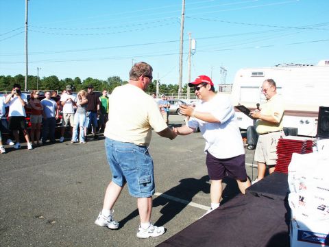 2001 Mercury Grand Marquis - Attendees gather at an outdoor car show event, with a trailer and awards table visible in the background.