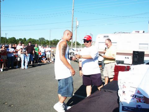 2001 Mercury Grand Marquis - Awards ceremony at an outdoor car show with spectators and a trailer in the background.