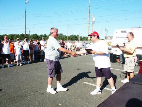 2001 Mercury Grand Marquis - Outdoor event with people gathered, two men shaking hands, and a trailer visible.