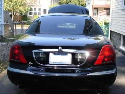 1997 Ford Crown Victoria - The rear of a black Lincoln Continental is visible, with "CONTINENTAL" badging on the taillights.