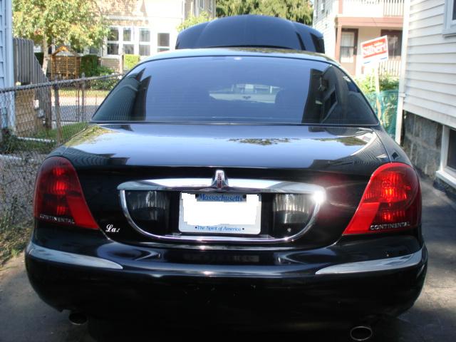 Black Lincoln Continental sedan, rear view, showing taillights and license plate
