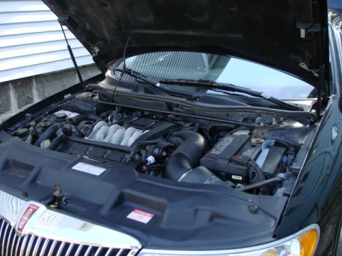 1997 Ford Crown Victoria - The engine compartment of a black car is shown with the hood raised.