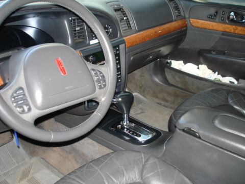 1997 Ford Crown Victoria - The interior of a Lincoln shows its dashboard, steering wheel, and center console.
