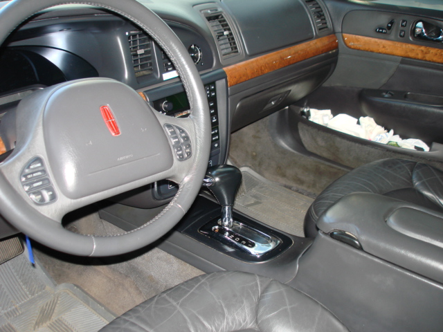 Lincoln interior with leather seats, wood trim, and a Lincoln emblem on the steering wheel