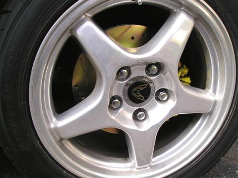 1994 Pontiac Trans Am - A close-up view of a vehicle's wheel and braking system, a distinctive emblem on the wheel's center cap.
