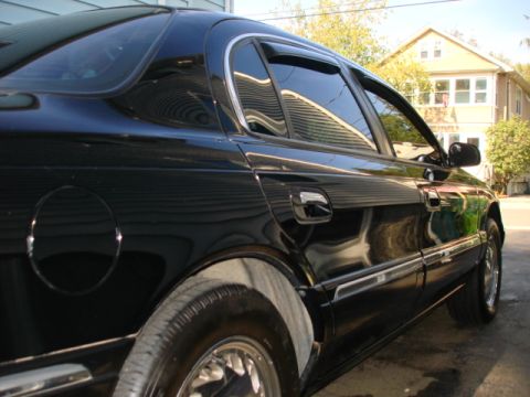 1997 Ford Crown Victoria - Side view of a black 1997 Ford Crown Victoria parked outdoors.