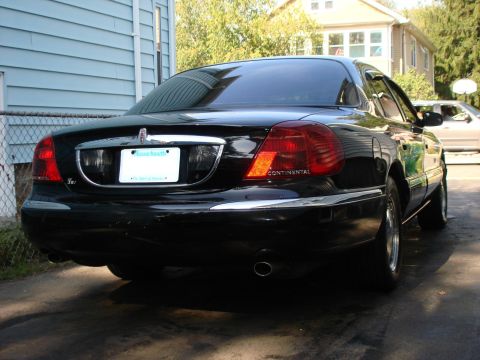 1997 Ford Crown Victoria - Rear view of a black Lincoln Continental sedan parked outdoors. The 'Continental' badge is visible on the taillight assembly.