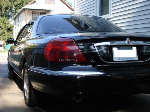 1997 Ford Crown Victoria - Rear view of a black Lincoln Continental with 'CONTINENTAL' and 'Lxi' badging visible.