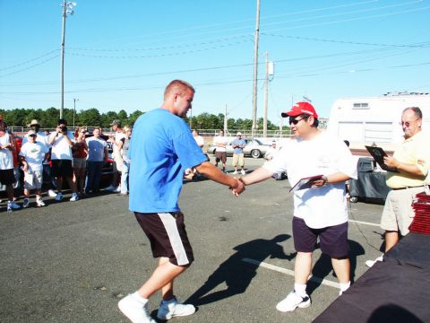 2001 Mercury Grand Marquis - A car show award ceremony takes place outdoors on a sunny day with spectators watching.