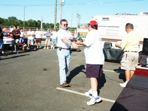 2001 Mercury Grand Marquis - People gather at an outdoor car show, with some interacting in the foreground.