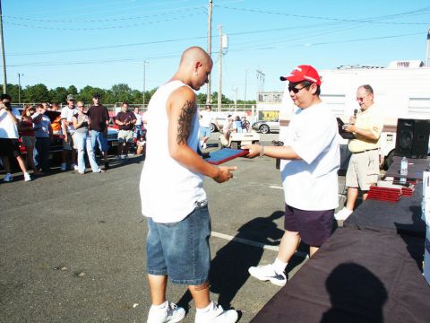 2001 Mercury Grand Marquis - An award is presented at an outdoor event with spectators and vehicles visible.