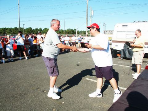 2001 Mercury Grand Marquis - A car show awards ceremony takes place outdoors with spectators and vehicles present.