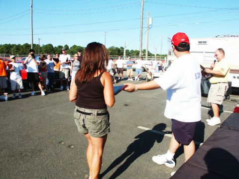 2001 Mercury Grand Marquis - Attendees mingle at a car show event, with a woman in the foreground and a man presenting an award.