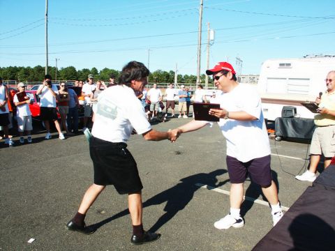 2001 Mercury Grand Marquis - Two men shaking hands at an outdoor event, possibly a car show award ceremony.