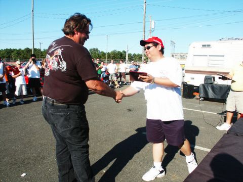 2001 Mercury Grand Marquis - Two men are shaking hands at an outdoor event, possibly a car show award ceremony.