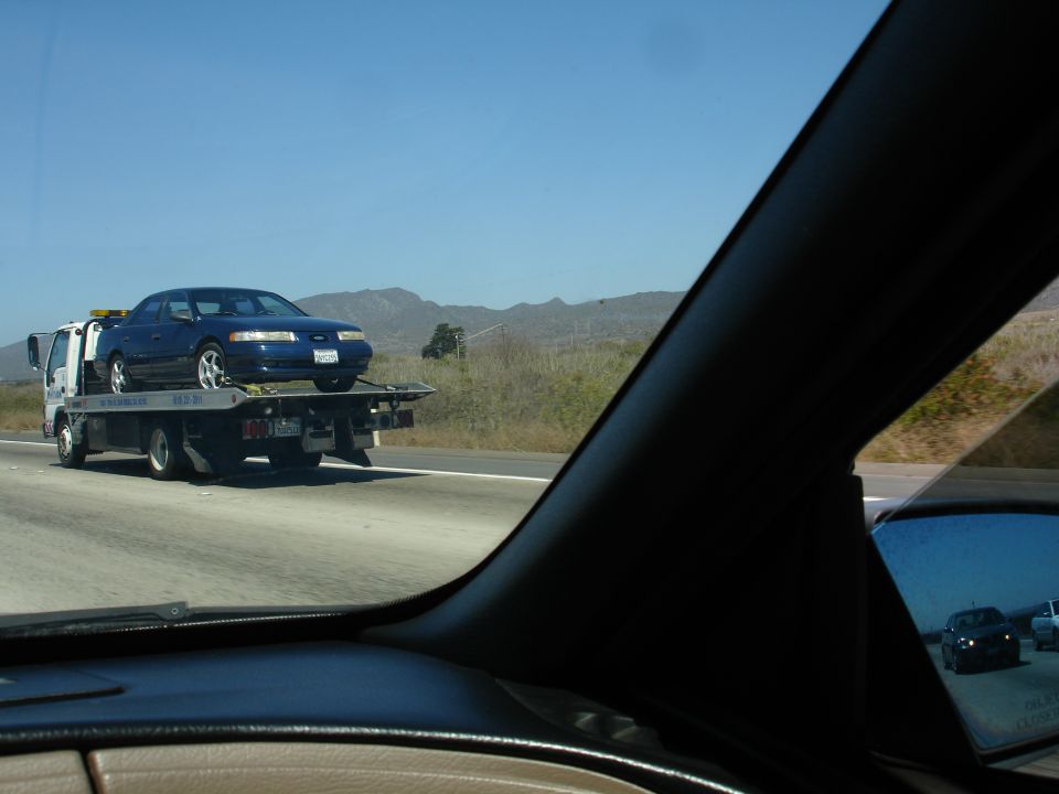 Blue 1992 Ford Taurus on tow truck, 3q-front view
