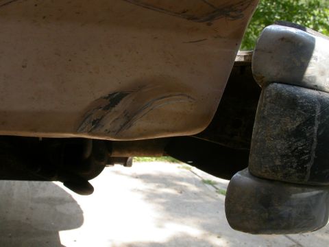 1990 Ford Bronco - Close-up of a scratched rear bumper and stacked tires on an unidentified vehicle.