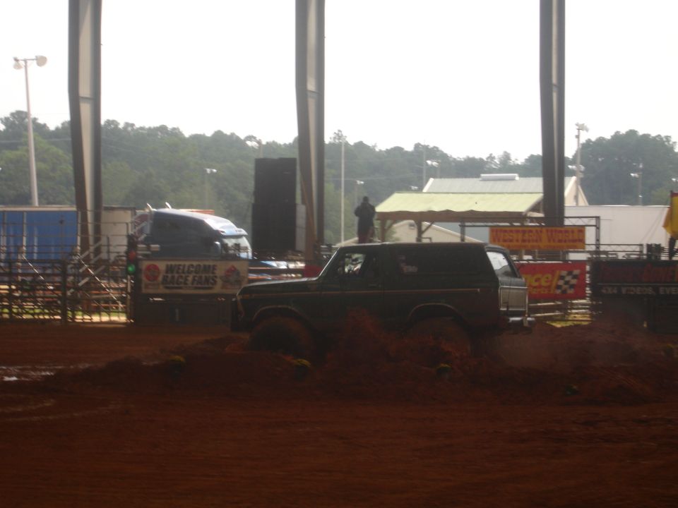 Dark 1989 Ford Bronco driving through mud