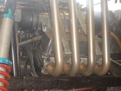 1989 Ford Bronco - Close-up view of an engine bay showing exhaust headers and suspension parts.