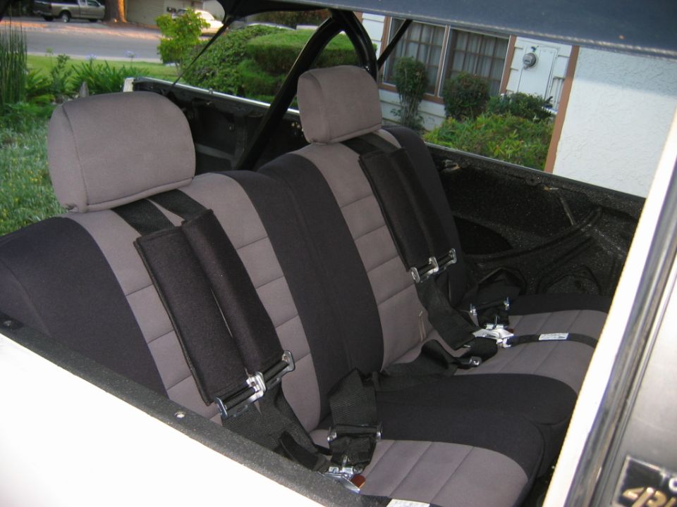 Interior view of gray and black seats with racing seat belts